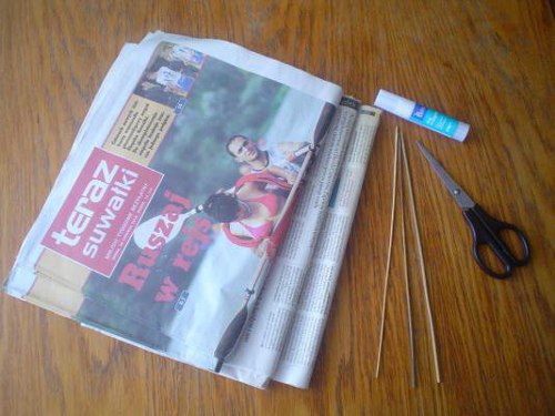 przybory potrzebne do zrobienia koszyka z wikliny papierowej, klej w sztyfcie, nożyczki, gazety, patyczek do szaszłyków